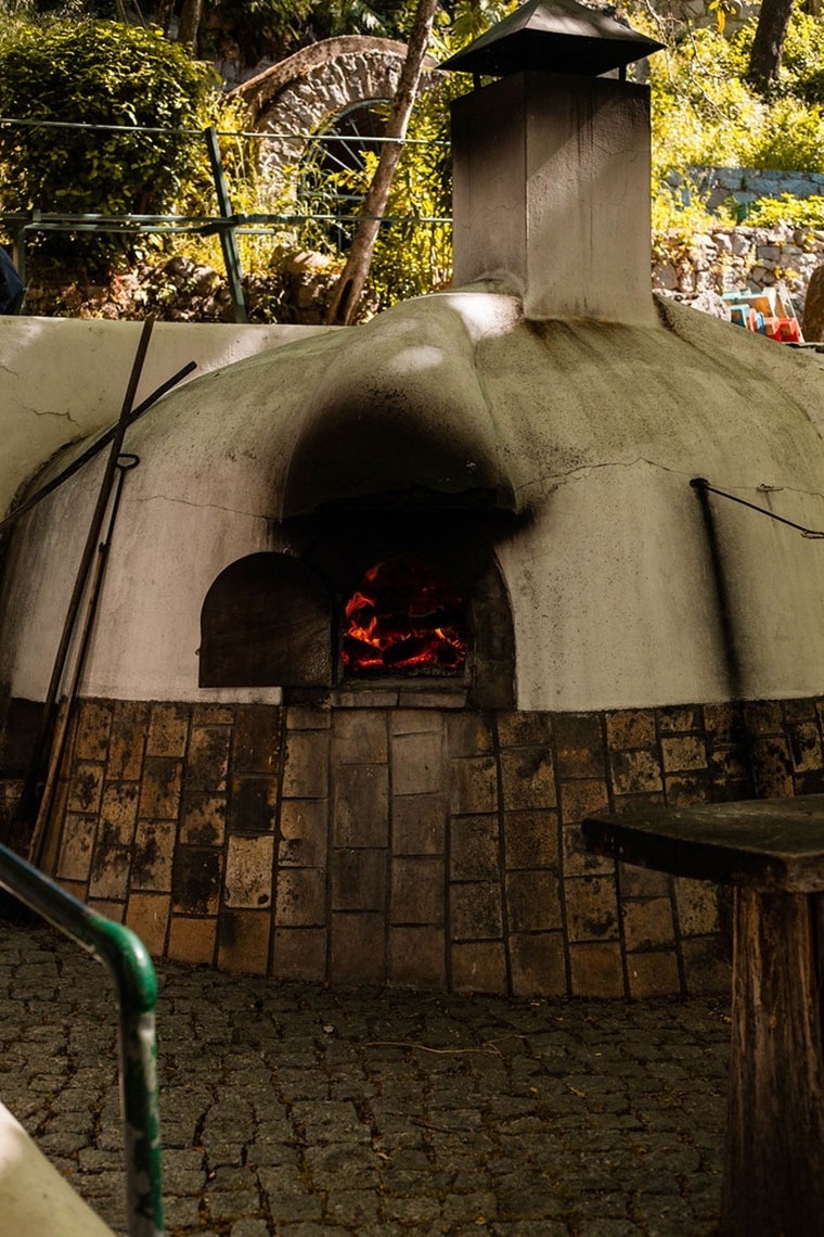 Forno a lenha rústico no Monchique Resort & SPA by Flagworld Hotels, perfeito para pizzas e pães.