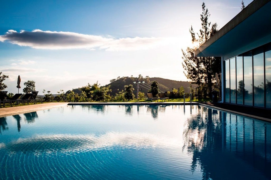 Piscina infinita deslumbrante com vista para montanhas, parte do Monchique Resort & SPA by Flagworld Hotels.