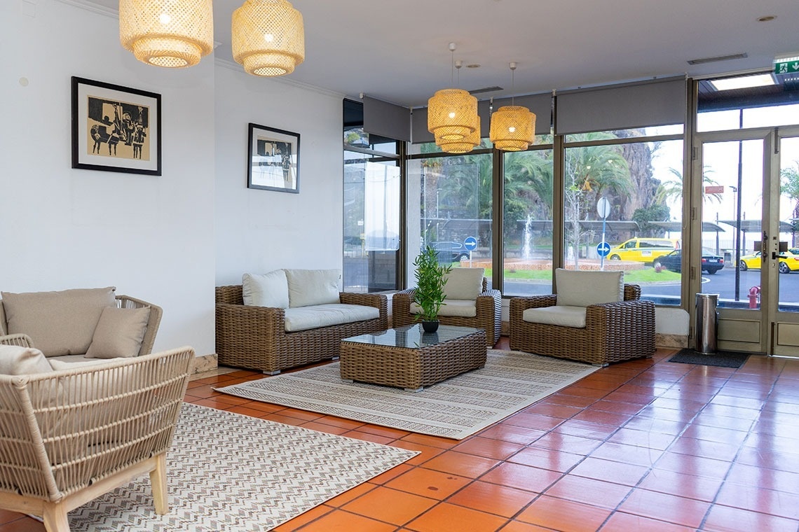 Welcome lobby at Flag Hotel Madeira - Ribeira Brava. Wicker furniture, rattan lamps, glass coffee table.