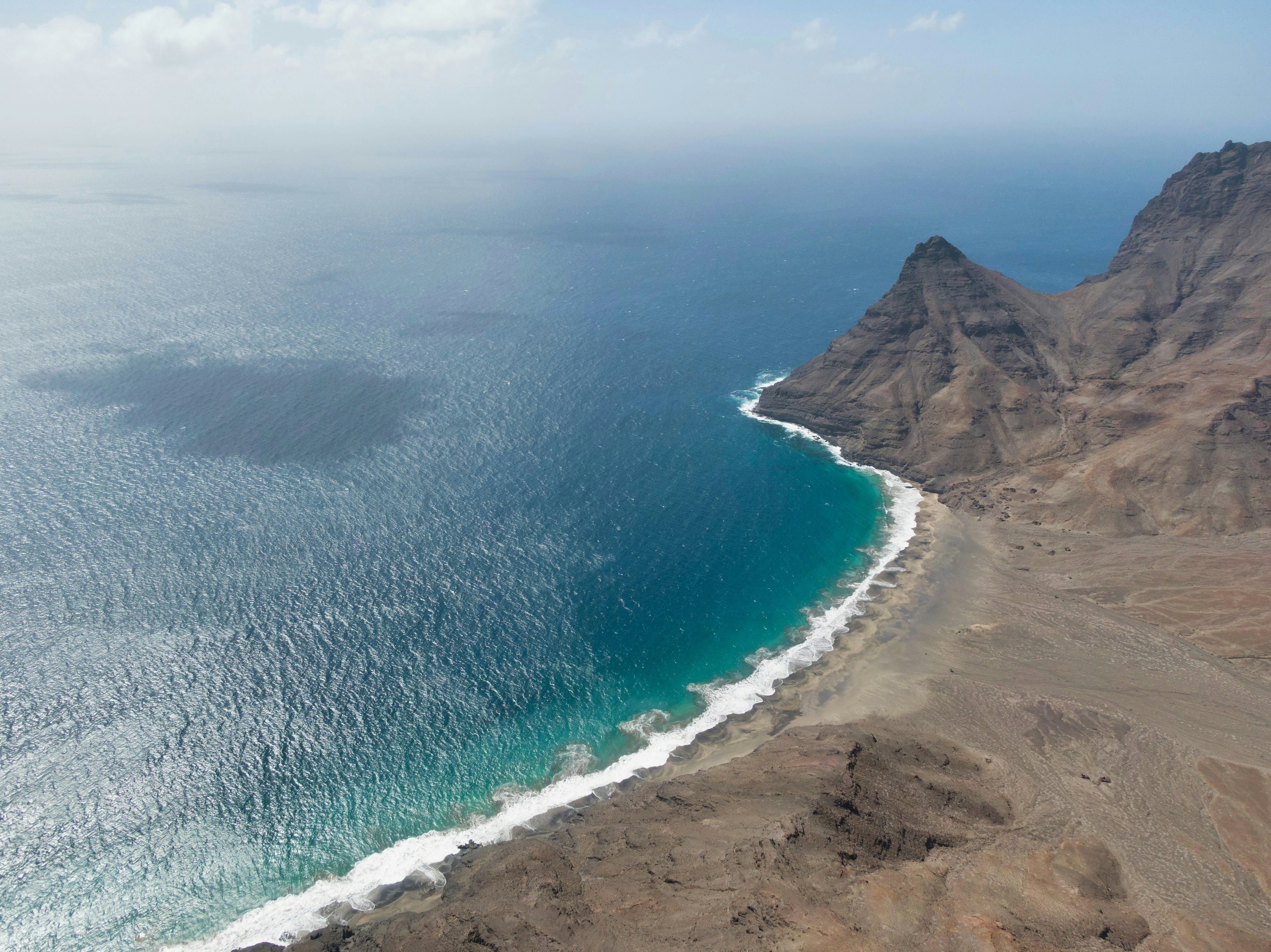 uma vista aérea de um oceano com montanhas ao fundo