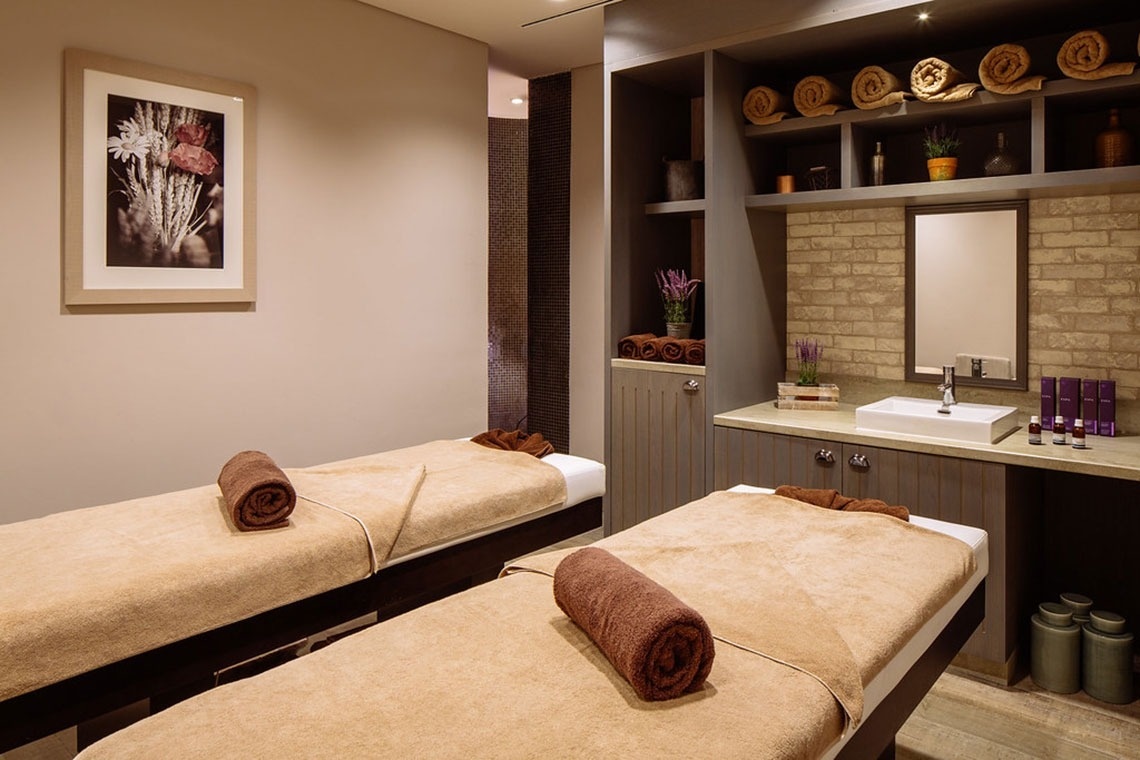 Monchique Resort & SPA: salas de massagem com macas e toalhas,pias e arte na parede.