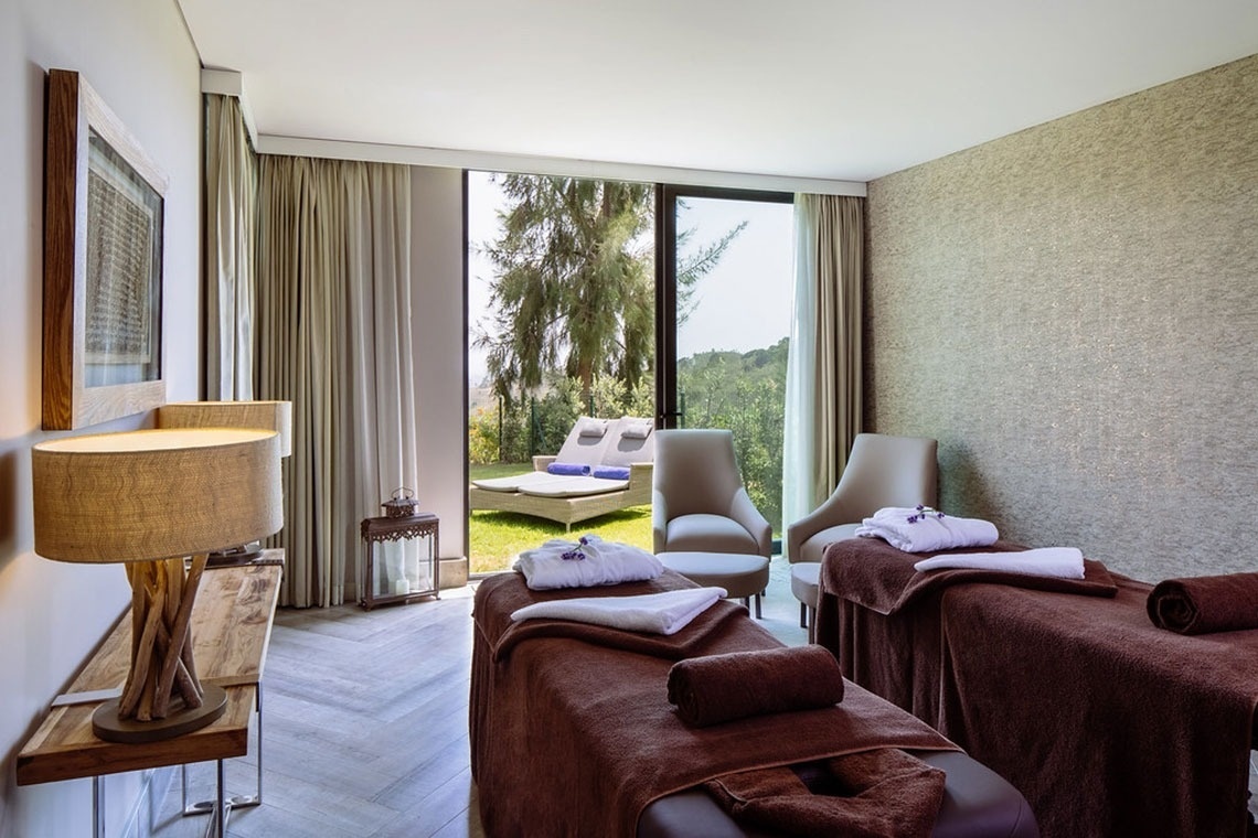 Ambiente relaxante no Monchique Resort & SPA by Flagworld Hotels | Website oficial, com macas para massagem e vista para o exterior.
