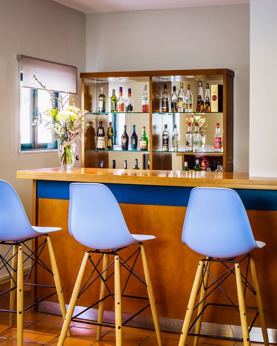 Bar moderno con sillas pastel y botellas de licor, Flag Hotel Braga