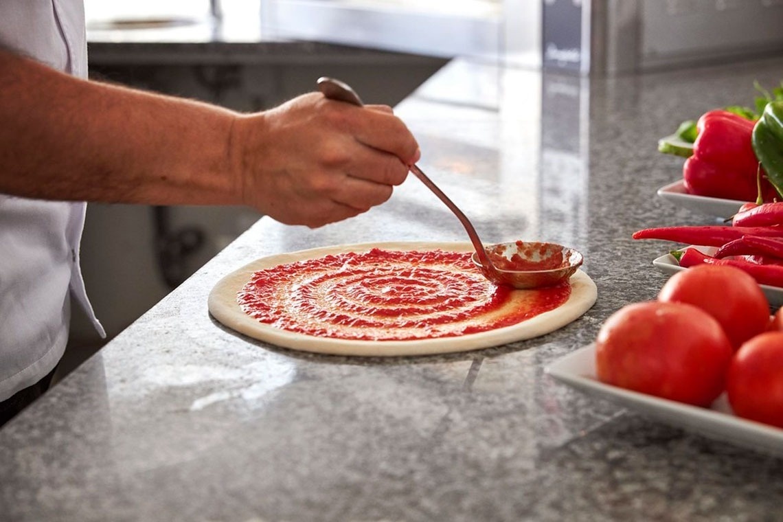 Monchique Resort & SPA: chef espalha molho na pizza, com ingredientes frescos à vista.
