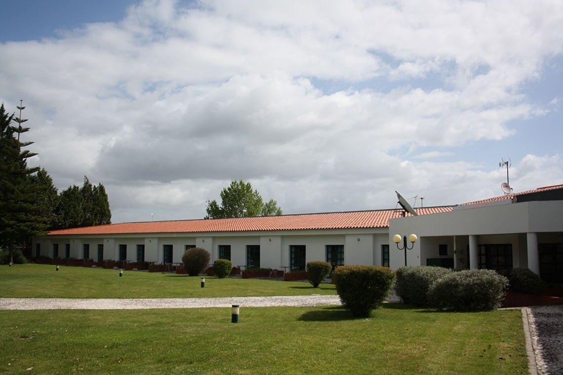 a row of white buildings with a blue sky in the background