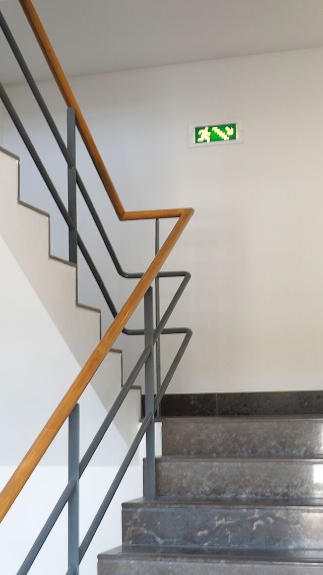 Escada moderna com sinal de emergência e corrimão de madeira no Flag Hotel Porto-Maia | Website oficial.