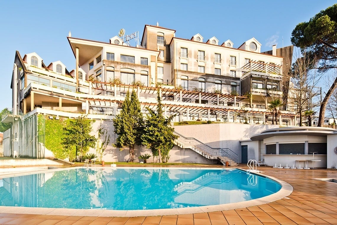 una piscina frente a un gran edificio con la palabra fancy en la parte superior