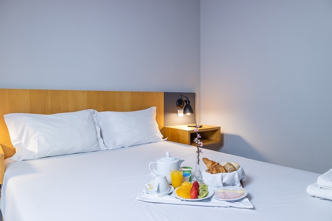 Desayuno en la cama en Flag Hotel Braga. Disfrute de cruasanes, frutas y jugo en su habitación.