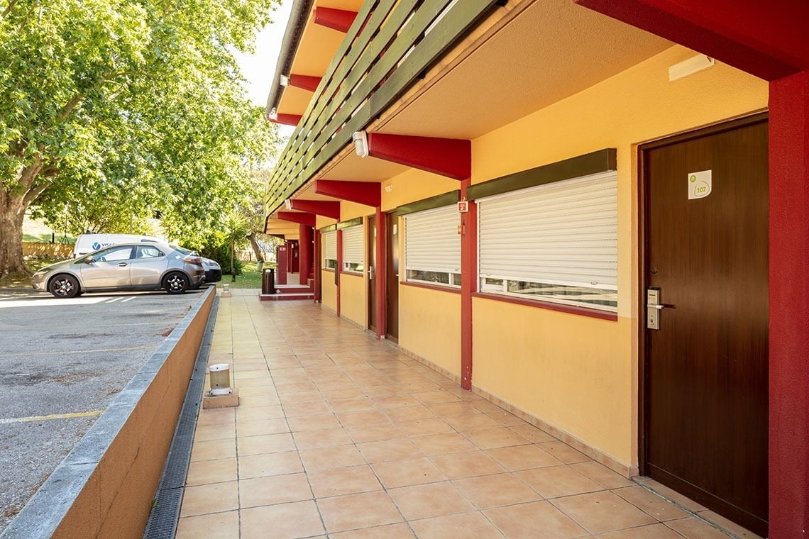 Campanile Setúbal: corredor com portas de hotel e estacionamento exterior.