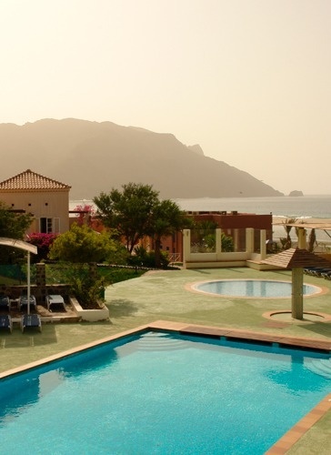 a large swimming pool with mountains in the background