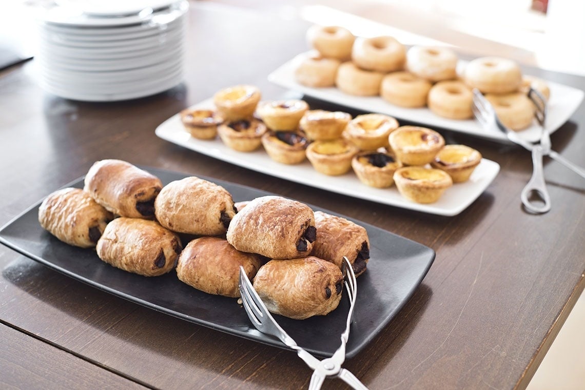 Desayuno buffet en Lam Hotel Estarreja: pasteles de nata, donuts y croissants de chocolate.