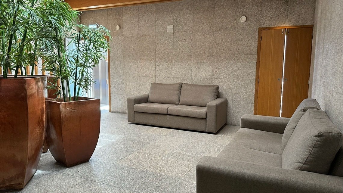 Elegant lobby with sofas, plants, and doors at Flag Hotel Barcelos.