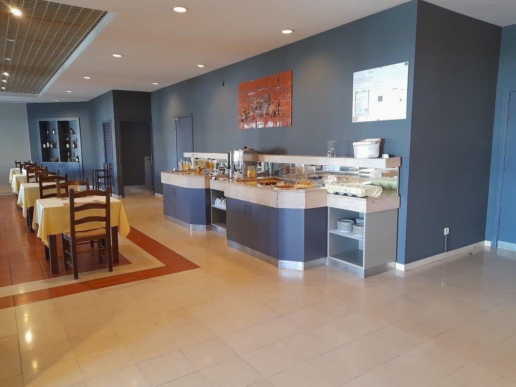 a buffet line in a restaurant with a painting on the wall above it