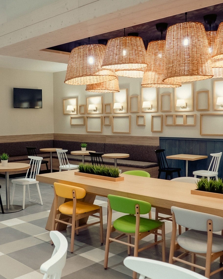 Modern hotel dining area with woven lamps, colorful chairs & tables. Flag Hotel Caldas da Rainha | Official website