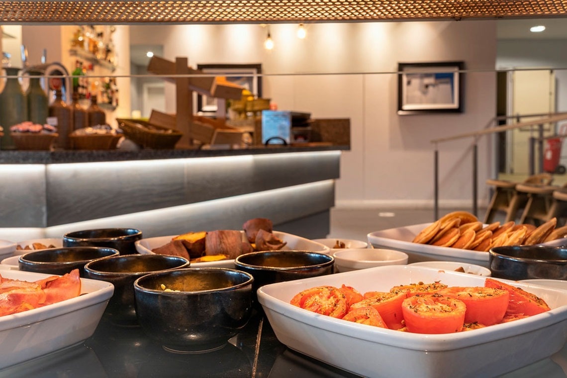 Buffet de café da manhã com tomates, batatas e panquecas no Monchique Resort & SPA.