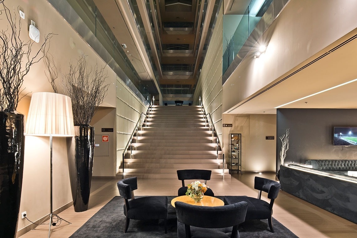 Golden Tulip Sao Joao da Madeira hotel lobby with grand staircase and lounge seating.
