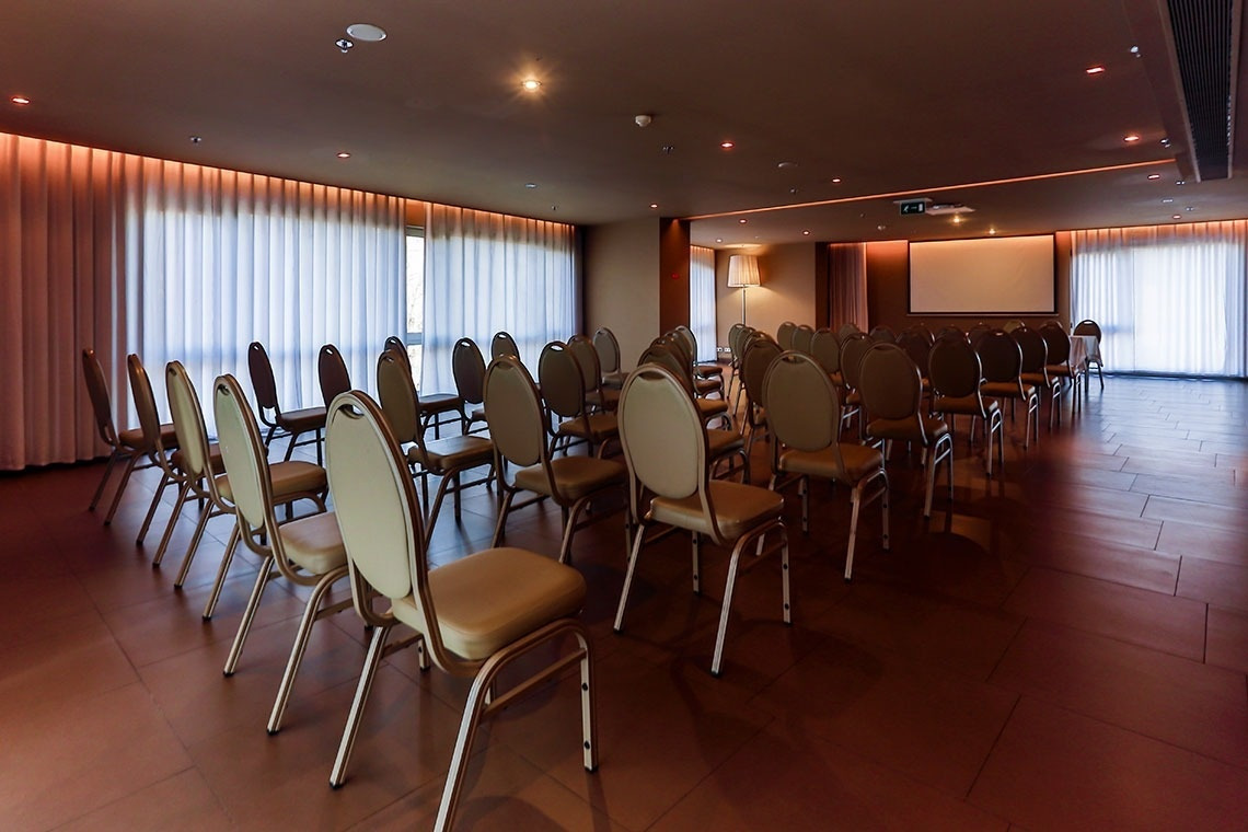 Chairs arranged in a modern conference room at Golden Tulip Sao Joao da Madeira | Official website.