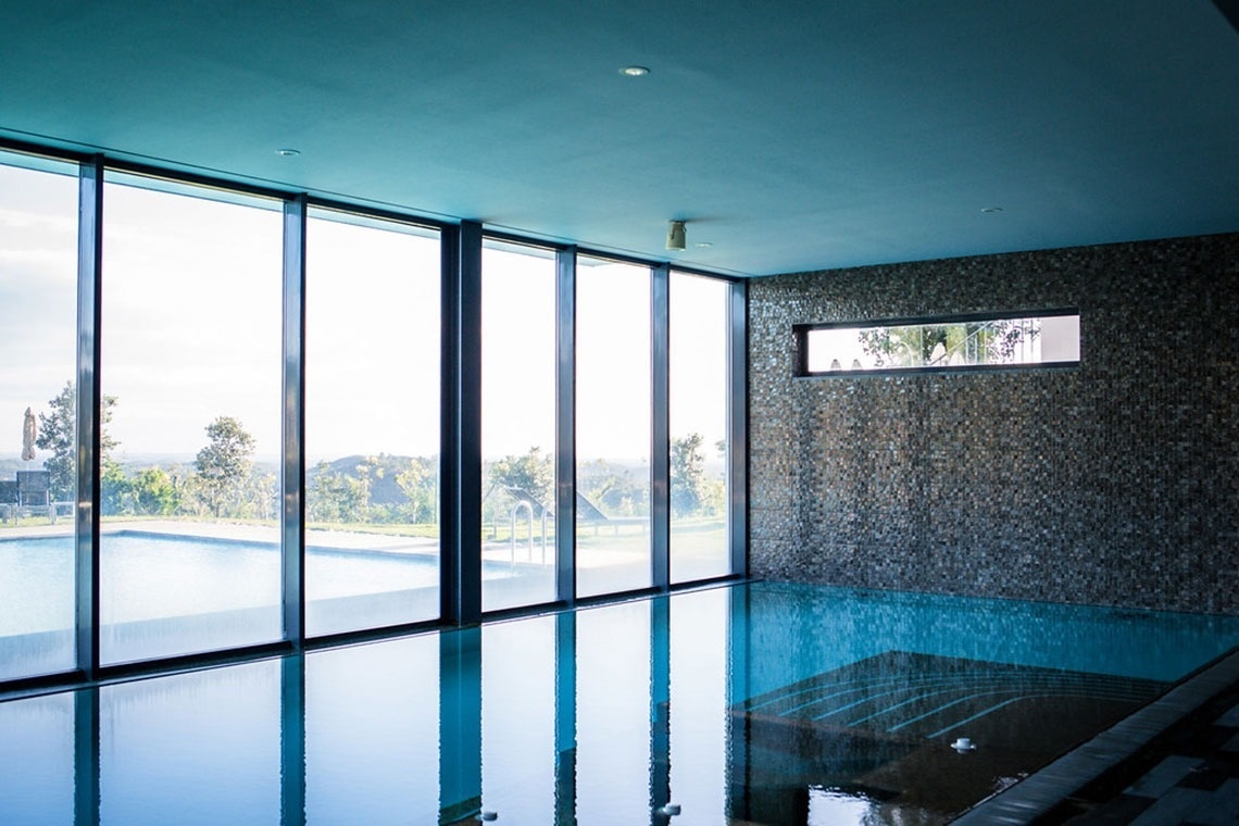 Piscina interior com vista para o exterior em Monchique Resort & SPA by Flagworld Hotels | Website oficial