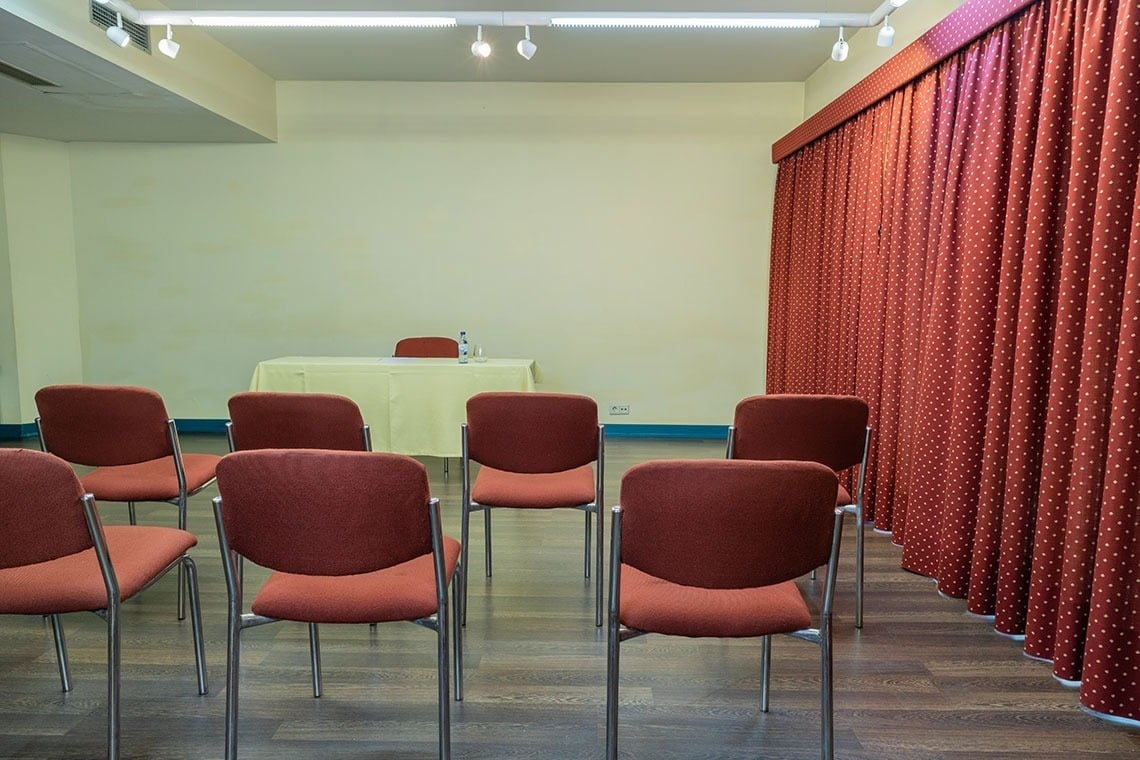 Conference room at Flag Hotel Guimarães Fafe with seating and draped curtains.