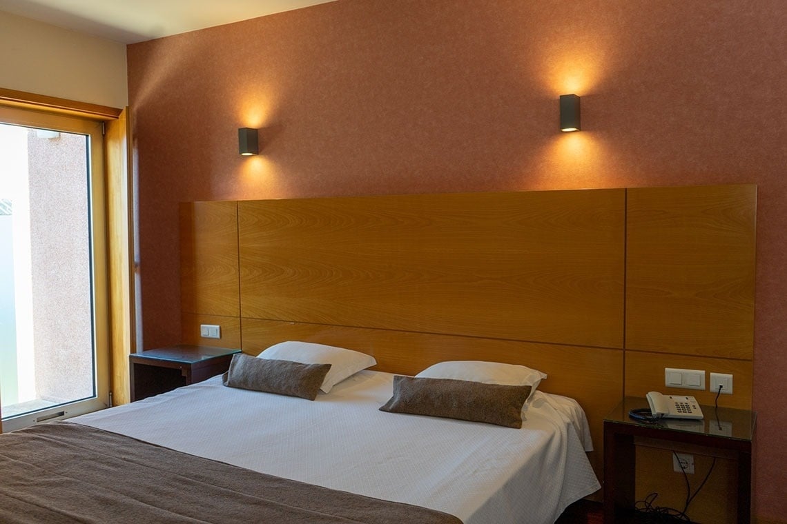 Modern hotel room at Flag Hotel Barcelos: bed, lamps, and desk.