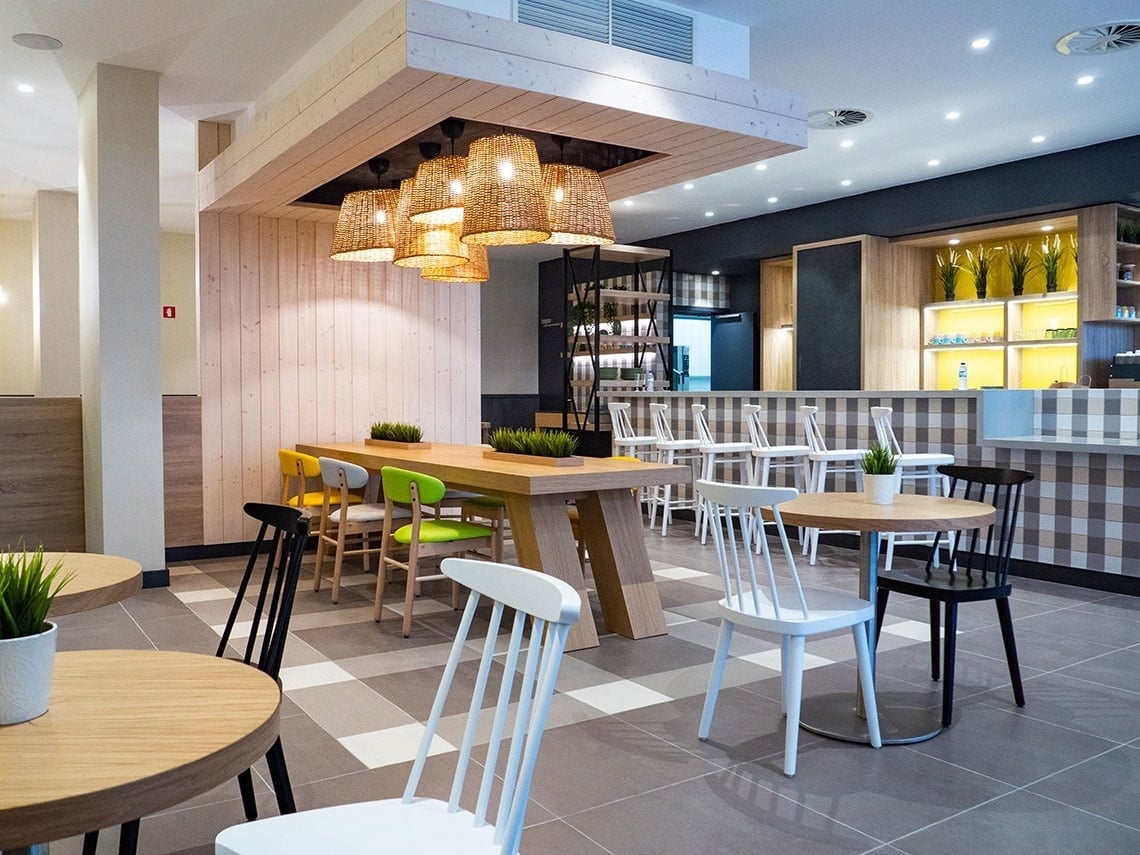 Modern dining area with wooden tables and chairs at Flag Hotel Caldas da Rainha.
