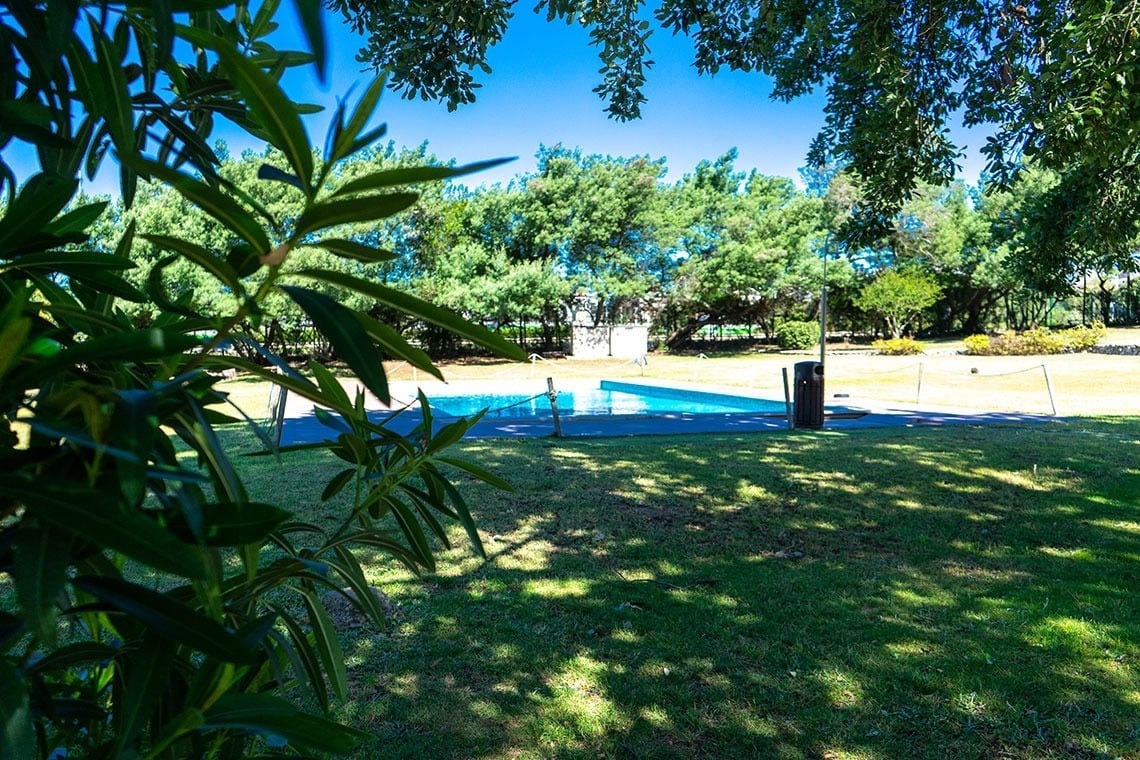 Piscina exterior e relvado com sombra das árvores, ideal para relaxar. Visite Campanile Setúbal | Website oficial.