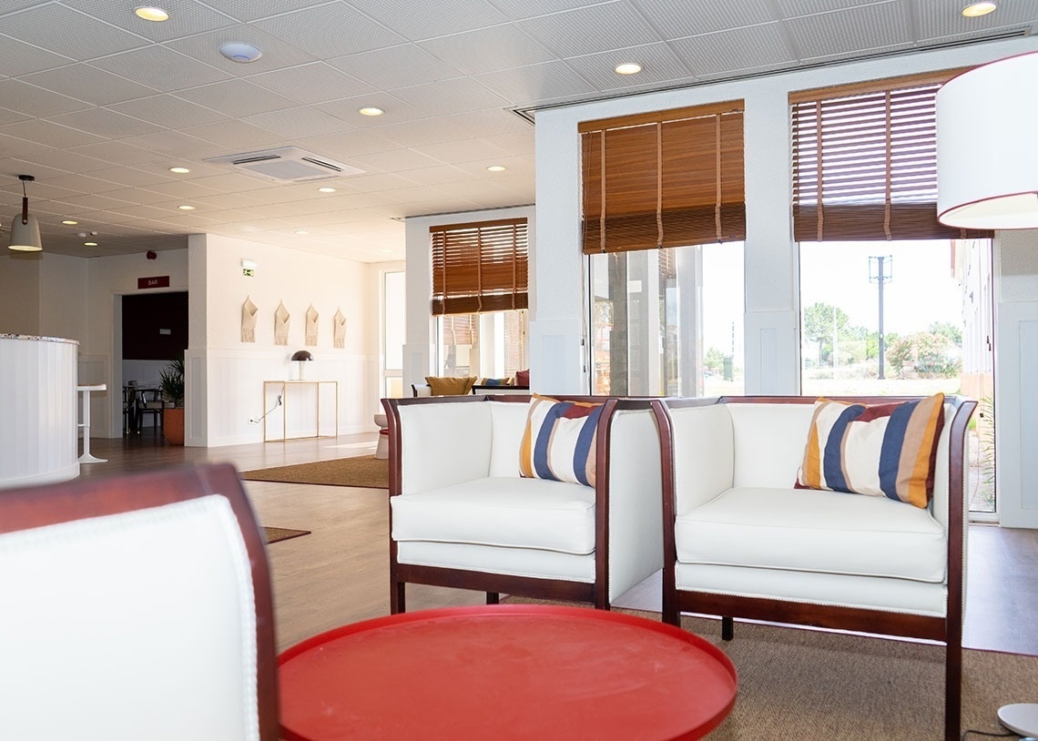 Modern hotel lobby with white sofas and colorful cushions. Flag Hotel Lisboa Oeiras.
