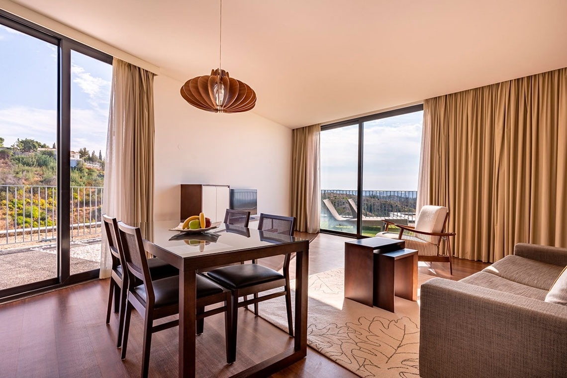 Sala de estar e jantar moderna com vista deslumbrante no Monchique Resort & SPA by Flagworld Hotels.