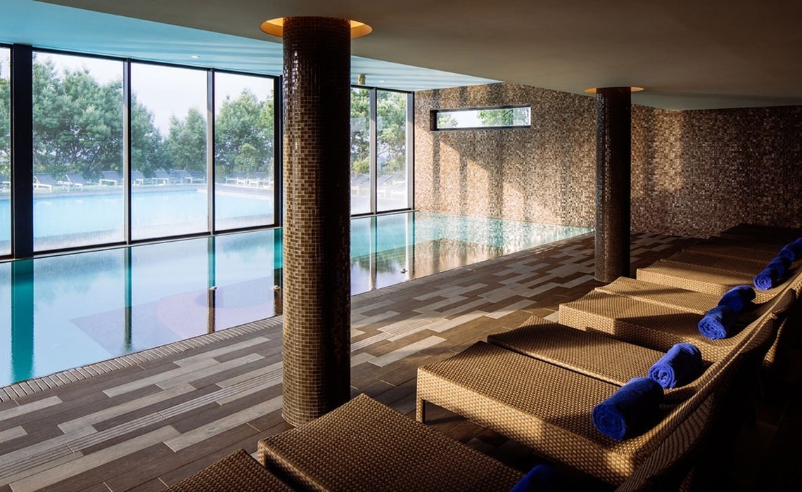 Piscina interior e espreguiçadeiras no Monchique Resort & SPA by Flagworld Hotels | Website oficial