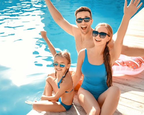 um homem está brincando com dois cachorros na praia .