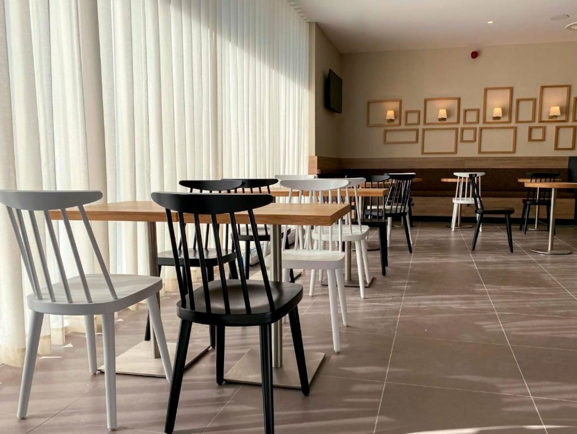 Modern dining area with light and dark chairs. Book at Flag Hotel Caldas da Rainha.