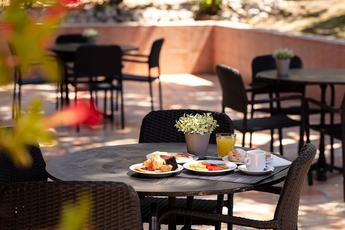 Café da manhã externo em mesa com croissants e frutas no Campanile Setúbal. Reserve já!