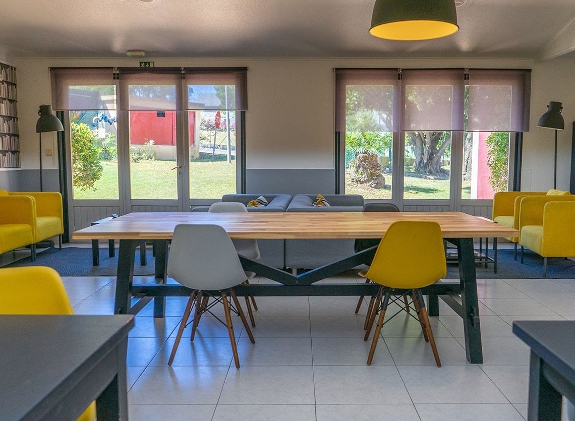Sala de estar do Campanile Setúbal com mesas, cadeiras e sofás, ideal para relaxar.