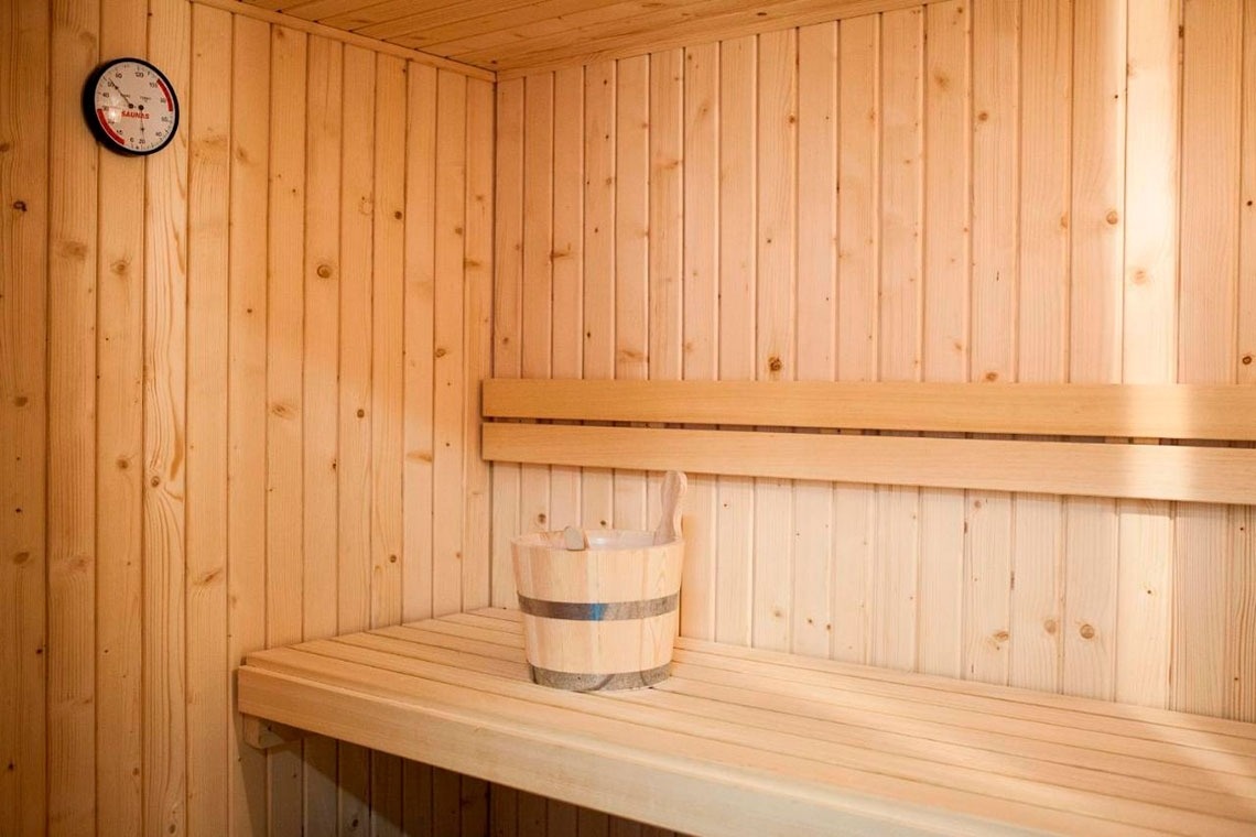 Sauna de hotel em madeira clara, com balde e concha. Flag Hotel Aljustrel. Visite o website oficial.