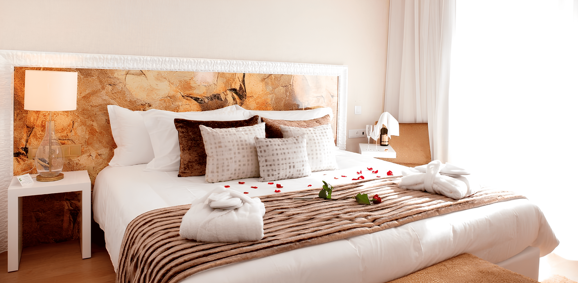 um quarto com uma cama e uma mesa com uma garrafa de vinho