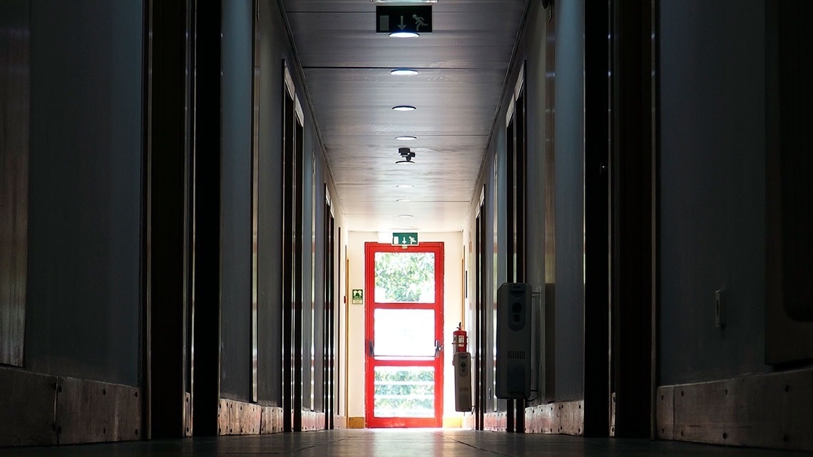 Corredor de hotel com porta vermelha ao fundo. Flag Hotel Porto-Maia | Site oficial.