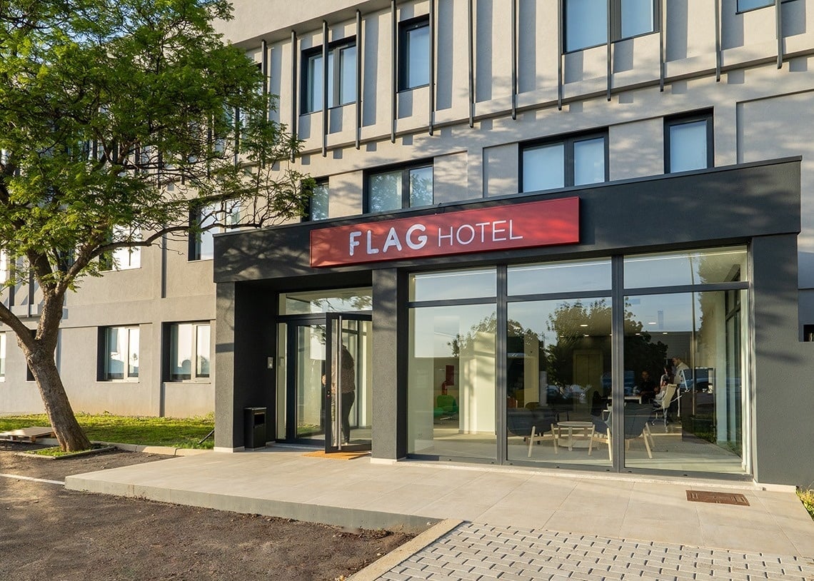 una puerta giratoria conduce a la entrada del hotel bandera