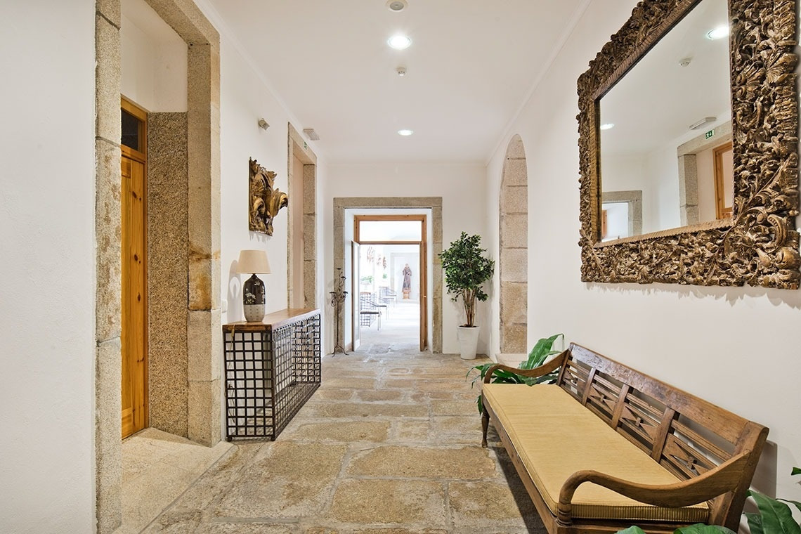 Lam Hotel Convento do Desagravo: Pasillo clásico con espejo barroco y banco de madera.