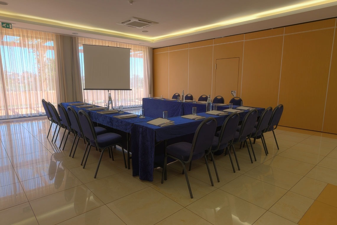 Sala de reuniones con mesas y sillas, ideal para eventos en Lam Hotel Estarreja | Web oficial.