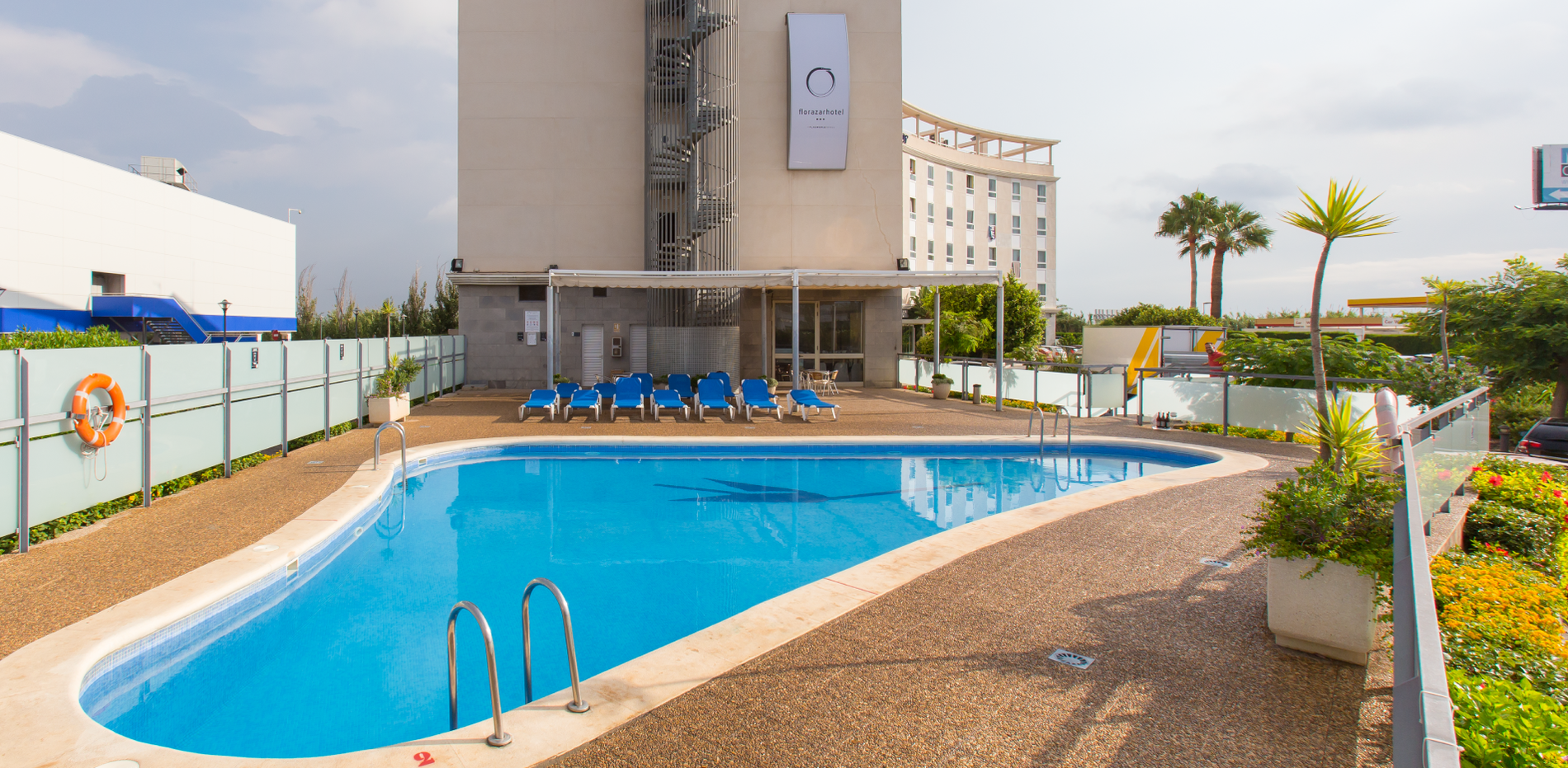 uma grande piscina em frente a um hotel