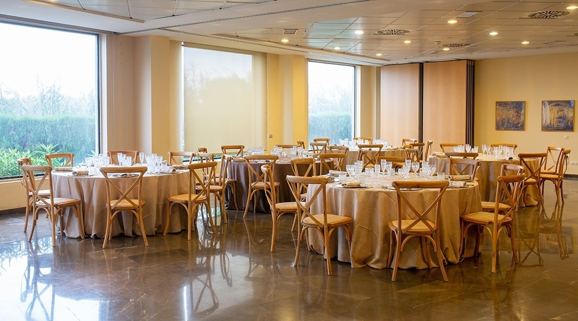 Salón de banquetes en Flag Hotel Valencia | Web oficial, mesas puestas con sillas de madera.