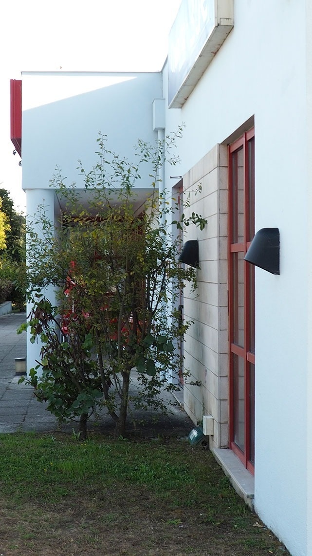 Fachada do Flag Hotel Porto-Maia com jardim e detalhes arquitetônicos modernos.