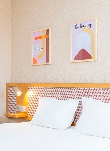 Cozy hotel room at Flag Hotel Lisboa Oeiras with modern art and comfortable bedding.