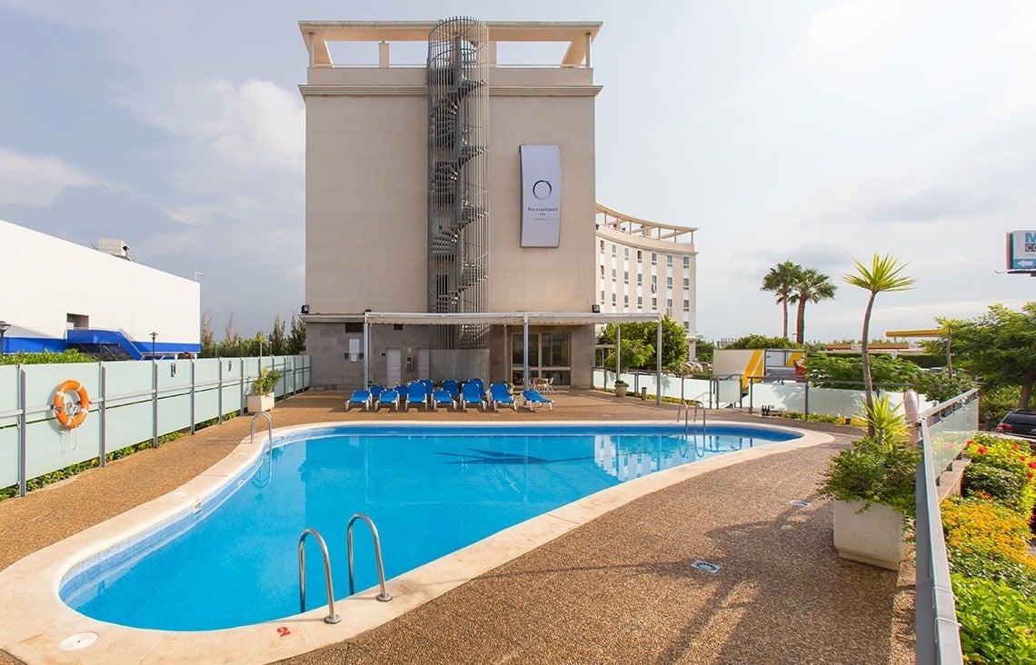 a hotel with a large swimming pool in front of it