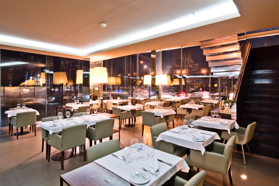 uma sala de jantar com mesas e cadeiras de madeira
