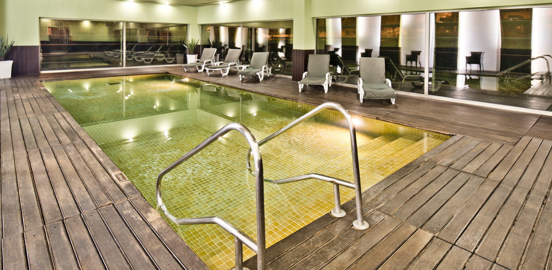 uma grande piscina com escadas e cadeiras ao redor