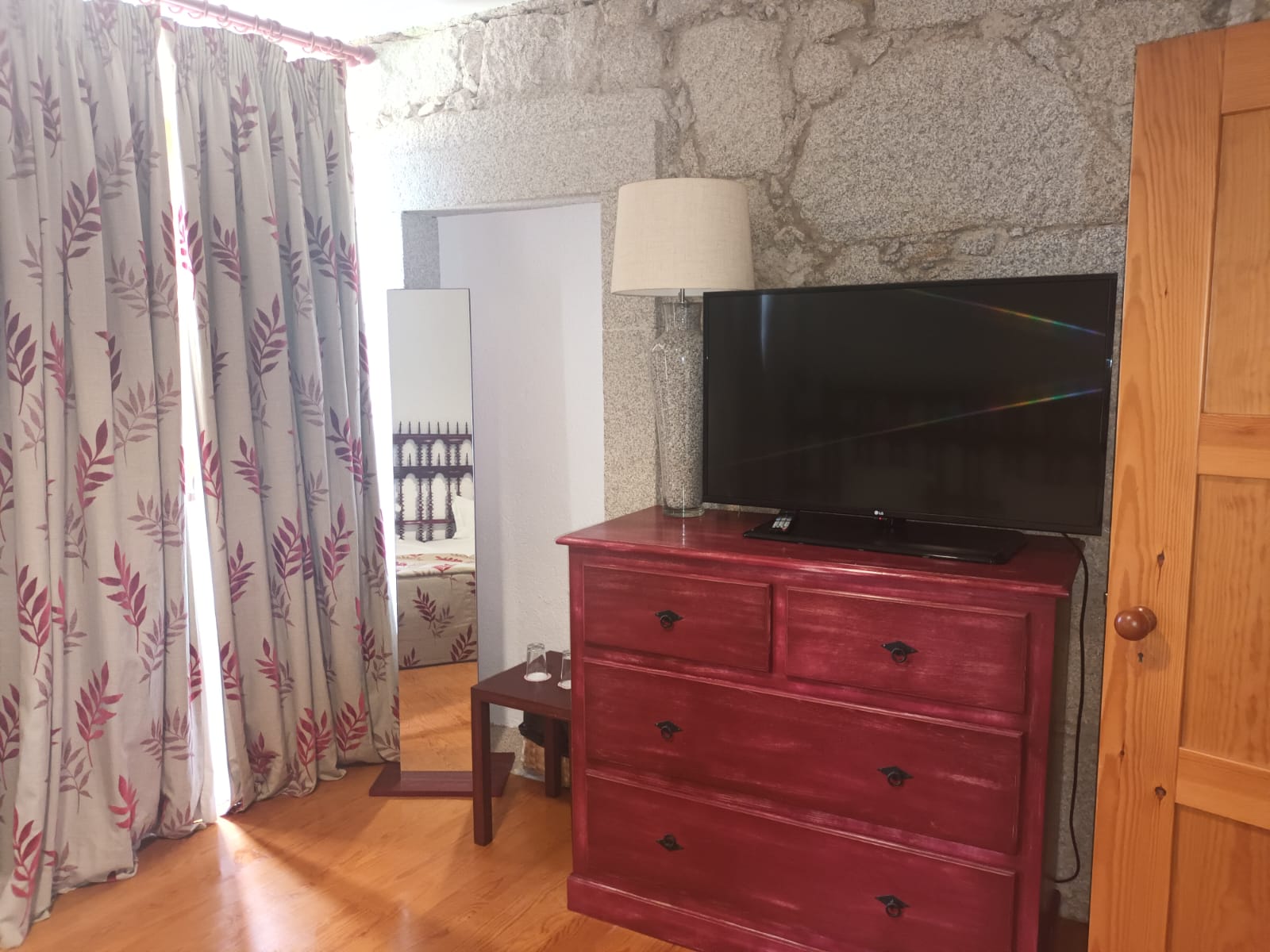 Quarto aconchegante com Lam Hotel Convento do Desagravo, espelho e porta de madeira.
