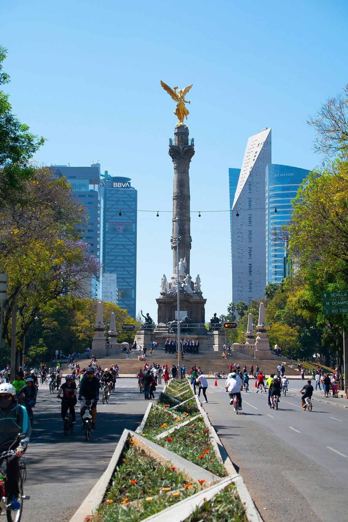 a busy city street with a bbva building in the background