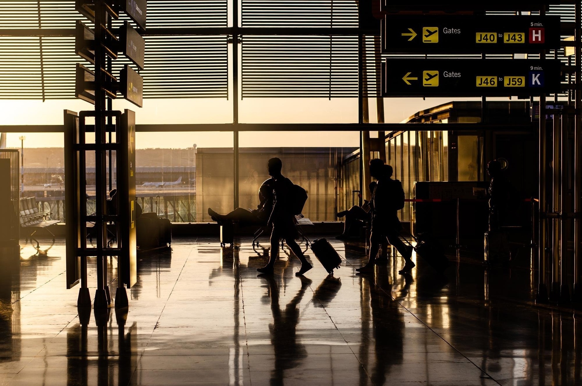 a woman walking down a hallway with a white suitcase