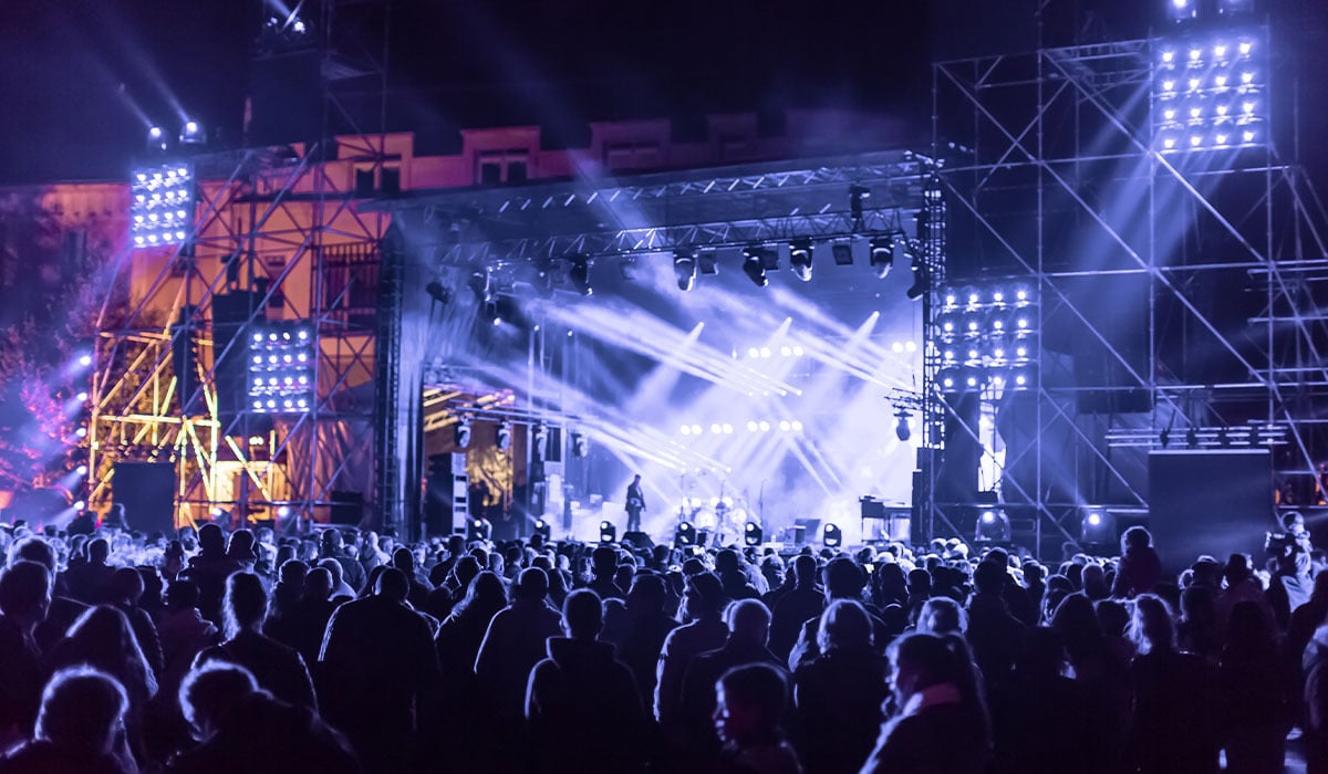 Concert crowd watching a stage with bright lights and Flash.